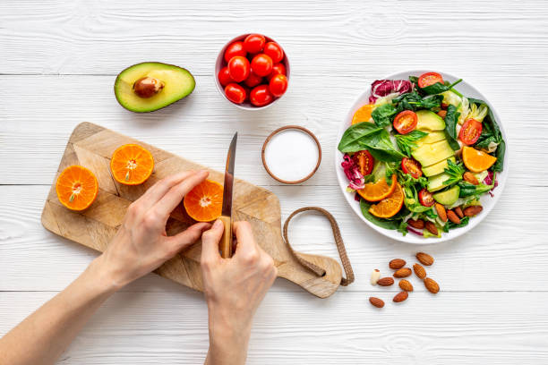 istock Hands cooking vegetarian salad with avocado and tomatoes 1450594963