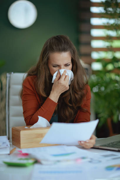 istock business owner woman blowing nose and working with documents 1450595102