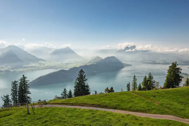 Hiking and mountain bike bicycle trail over lake Lucerne on Mountain Rigi with spectacular view to Bürgenstock and the Swiss alps