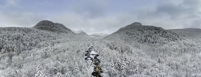 Panoramic Aerial View of Boreal Nature Forest and River in Winter After Snowstorm.\nRiviere Neilson River in Zec Batiscan Neilson, Saint-Raymond, Quebec, Canada.