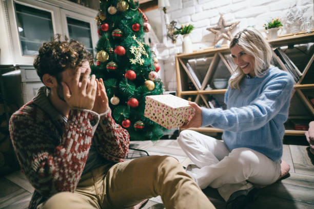istock Young couple giving each other Christmas presents. 1450625203