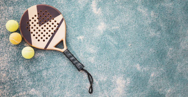 istock A paddle tennis racket resting on the ground with 3 balls, copyspace.Panoramic view. 1450628337