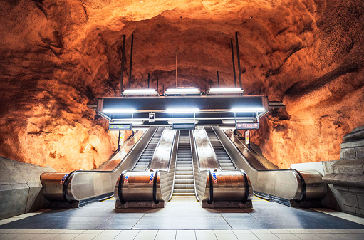 STOCKHOLM, SWEDEN - AUGUST 24, 2018: Person rides escalator in Stockholm metro (T-bana) underground station in Sweden. Stockholm metro is known for its artistic station interiors.