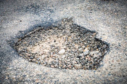 A deep pothole causing problems for drivers on an urban road.