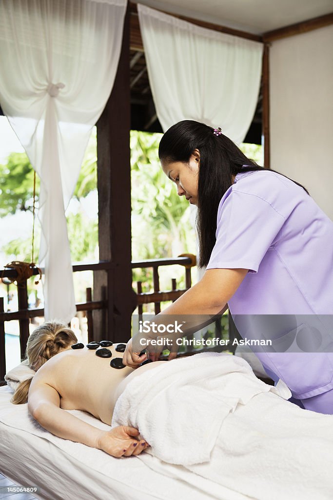 Woman having hot stone massage in spa  Heat - Temperature Stock Photo