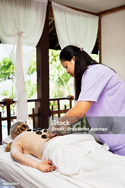 Woman Having Hot Stone Massage In Spa Stock Photo - Download Image Now - Heat - Temperature, Massaging, Multiracial Group