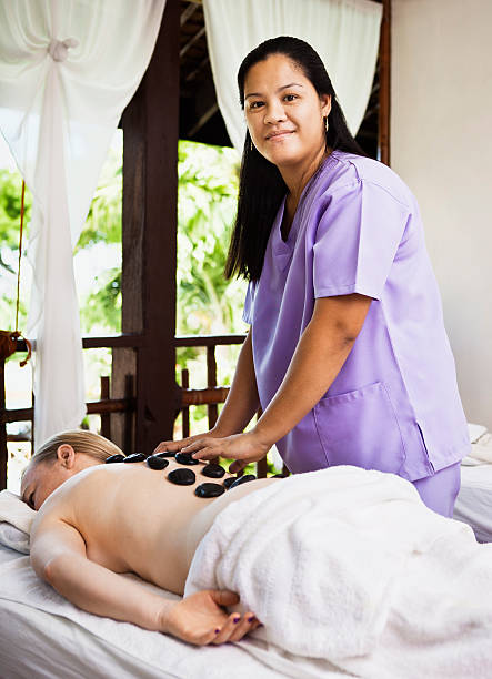 女性がホットストーンマッサージのスパ - massage therapist stone spa treatment working ストックフォトと画像