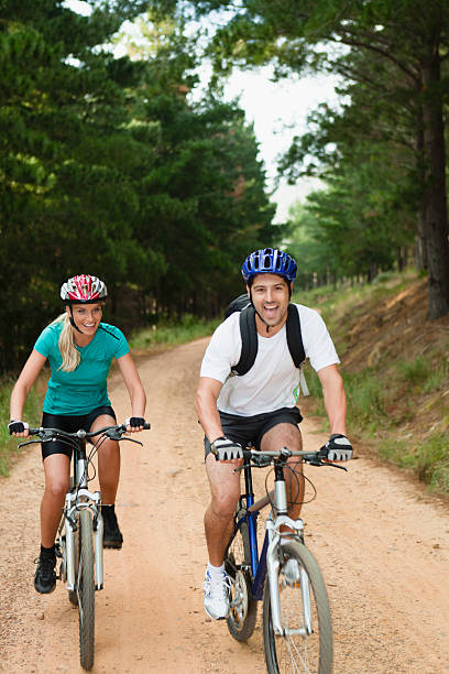 пара езда на горном велосипеде на грунтовая дорога - journey footpath exercising effort стоковые фото и изображения