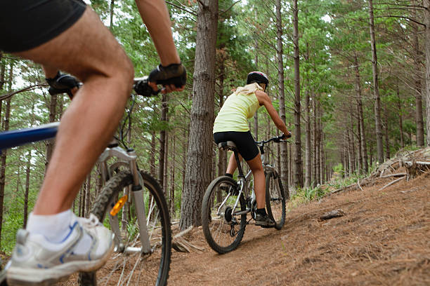 casal de mountain bike na floresta - journey footpath exercising effort - fotografias e filmes do acervo