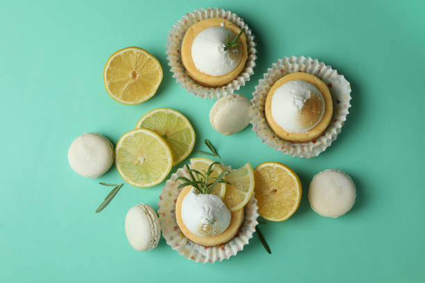 istock Lemon cupcakes, macaroons and ingredients on mint background 1450649045