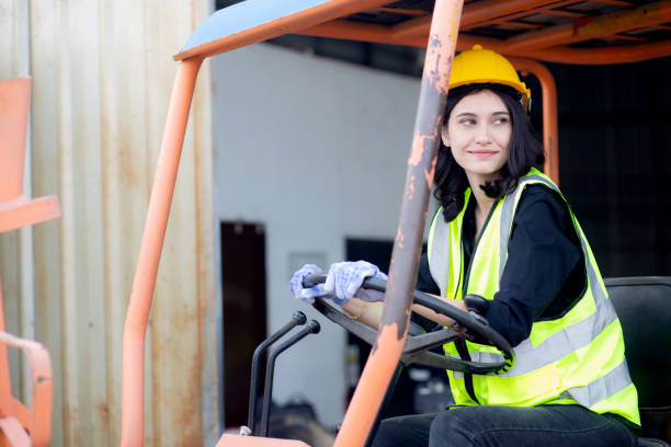 istock Young asian woman is foreman driving forklift at distribution warehouse, engineer working and shipping container at factory, cargo and logistic, one person, industry and transport concept. 1450649086