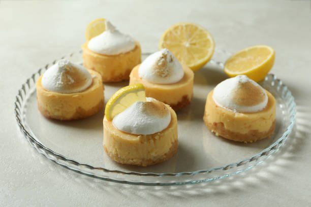 istock Tasty lemon cupcakes on tray on white textured table 1450649991