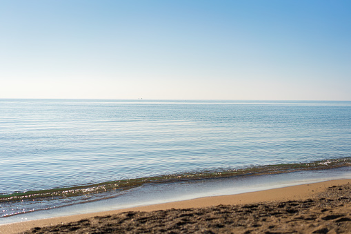 Summer sandy beach with a blue sea water