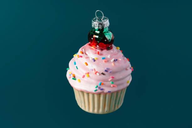 istock Christmas sweet cupcake bauble on dark green background 1450654147