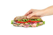 Female hand holds ciabatta sandwich, isolated on white background