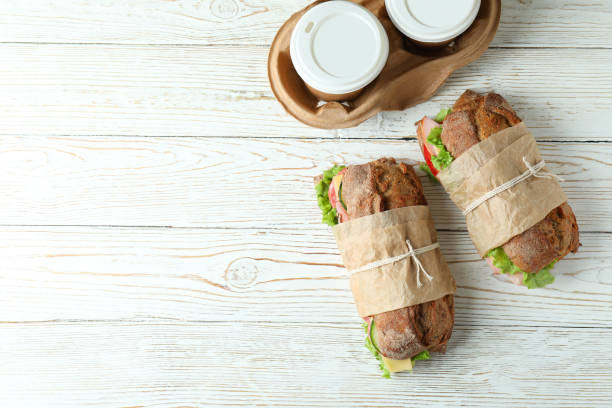 istock Ciabatta sandwiches and coffee cups on white wooden table 1450654561