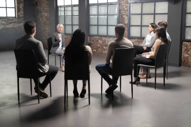 istock Senior female coach leading a group therapy in the office. 1450655169
