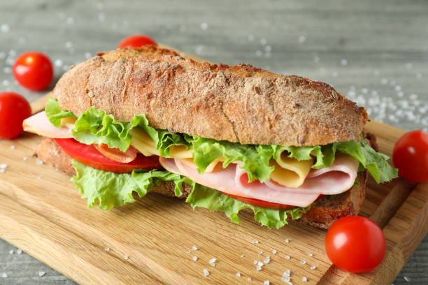 istock Board with ciabatta sandwich on gray textured table 1450655977