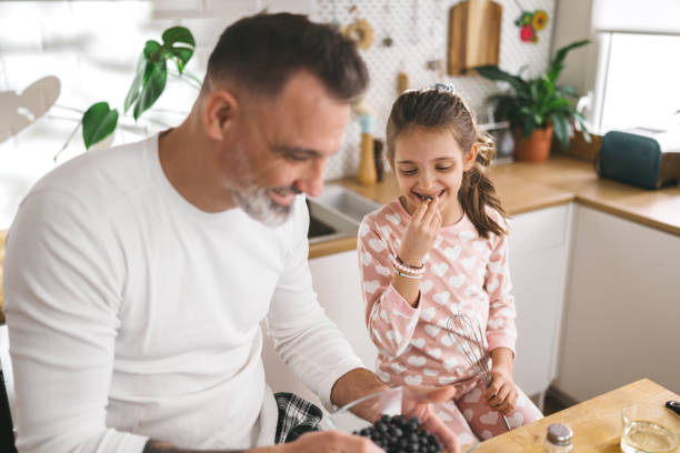 istock Happy father and daughter making breakfast in the kitchen. 1450656142