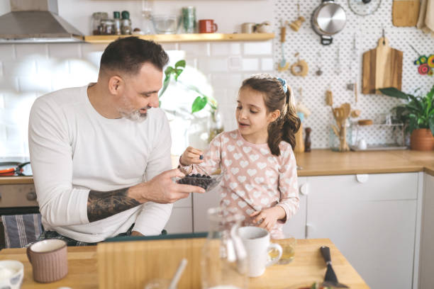 istock Happy father and daughter making breakfast in the kitchen. 1450656186