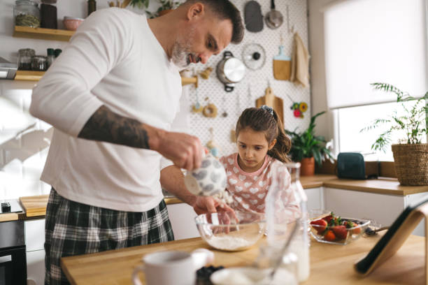 istock Happy father and daughter making breakfast in the kitchen. 1450657155