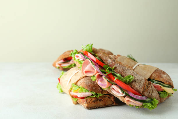 istock Tasty ciabatta sandwiches on white textured background 1450657213