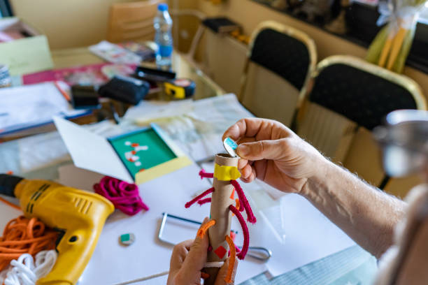 istock Senior man making toys from recycle card board 1450657320