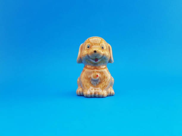 ein hoher engel eines keramikhandwerks mit einem alten goldbraunen hundecharakter - ceramic figure stock-fotos und bilder