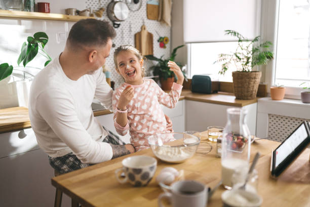 istock Happy father and daughter making breakfast in the kitchen. 1450658514