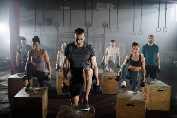 istock Athletic people having cross training with dumbbells in a gym. 1450658892