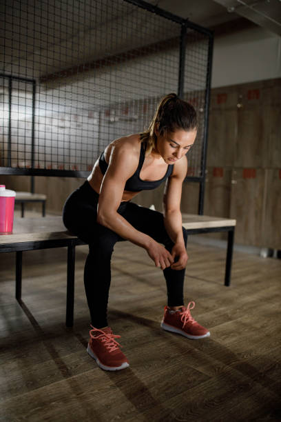 istock Exhausted athletic woman resting in dressing room. 1450660456