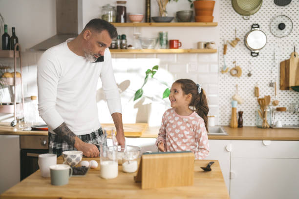 istock Happy father and daughter making breakfast in the kitchen. 1450660457