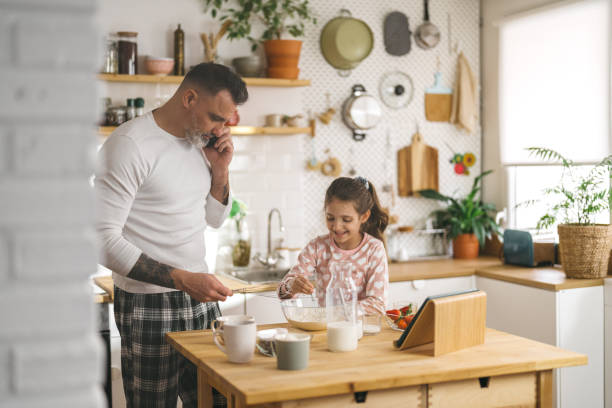 istock Happy father and daughter making breakfast in the kitchen. 1450660839