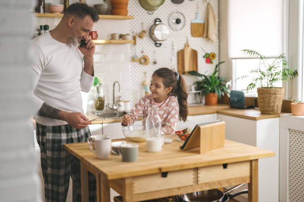 istock Happy father and daughter making breakfast in the kitchen. 1450660847