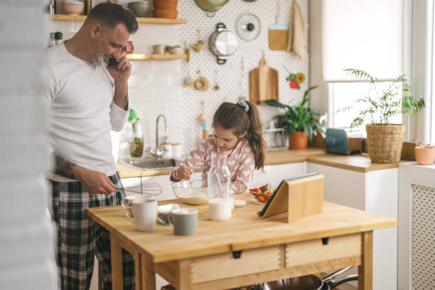 istock Happy father and daughter making breakfast in the kitchen. 1450660848
