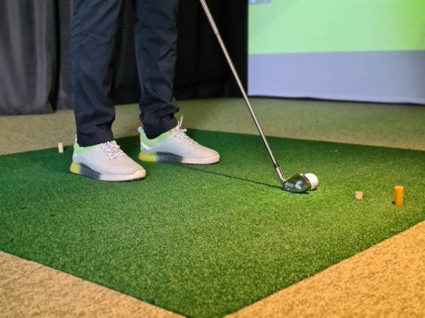 istock Professional male golfer playing golf indoors in golf simulator closeup 1450661396