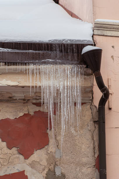 istock Icicles hanging from a roof of a building 1450665236