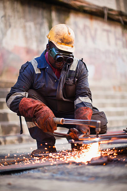 schweißer arbeiten auf dry dock - welder manual worker african descent steel worker stock-fotos und bilder