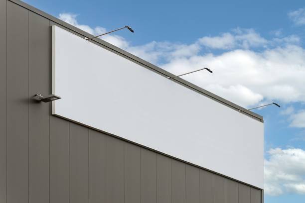 istock Big blank billboard on a gray building with the bright cloudy sky in the background 1450667698
