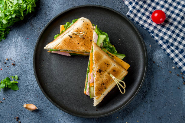 ham and cheese sandwich on black plate top view