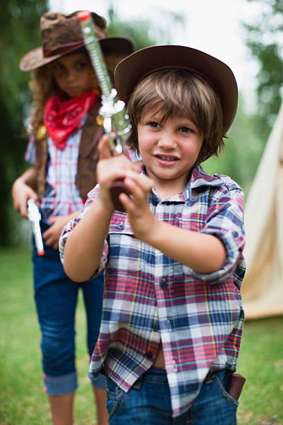 chłopiec w kapelusz kowbojski z zabawka pistol - child playing dressing up imagination zdjęcia i obrazy z banku zdjęć