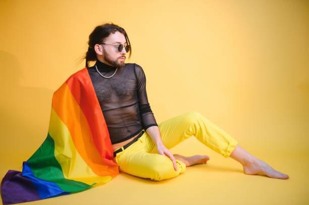 homem gay segurar bandeira listrada arco-íris isolado no retrato de estúdio de fundo colorido. pessoas estilo de vida moda lgbtq conceito - twink - fotografias e filmes do acervo