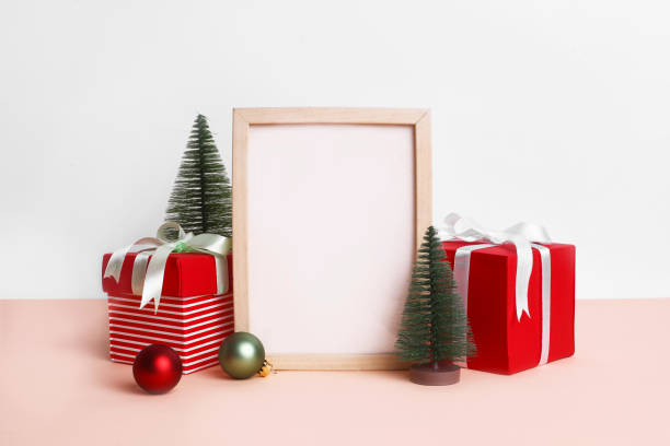 istock Christmas festival setup with blank frame in middle. Mock up setup on white background with red gift boxes, xmas tree and ribbons. 1450674302