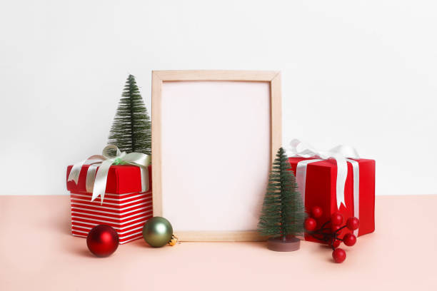 istock Christmas festival setup with blank frame in middle. Mock up setup on white background with red gift boxes, xmas tree and ribbons. 1450674308