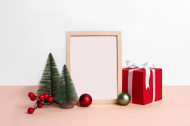 istock Christmas festival setup with blank frame in middle. Mock up setup on white background with red gift boxes, xmas tree and ribbons. 1450674312