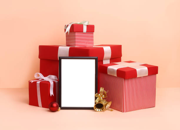 istock Christmas festival setup with blank frame in middle. Mock up setup on white background with red gift boxes, xmas tree and ribbons. 1450674331