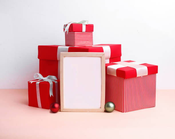 istock Christmas festival setup with blank frame in middle. Mock up setup on white background with red gift boxes, xmas tree and ribbons. 1450674337