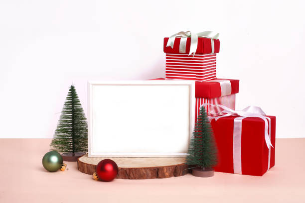 istock Christmas festival setup with blank frame in middle. Mock up setup on white background with red gift boxes, xmas tree and ribbons. 1450674389