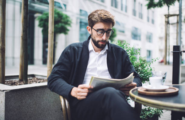 istock Peaceful man reading newspaper in cafe 1450675186