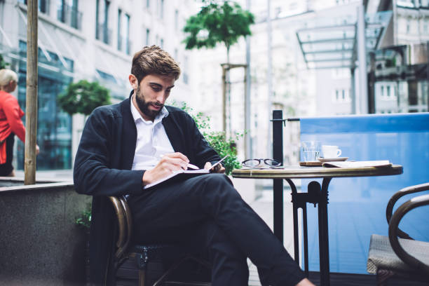 istock Preoccupied entrepreneur writing in notebook in cafe 1450675213
